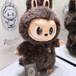Zimomo 58 cm – Édition Géante Collector Labubu Marron, figurine douce et espiègle en peluche brune, mise en avant dans un décor.